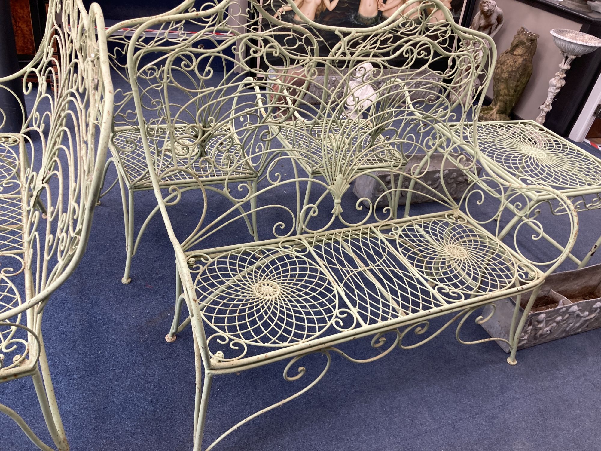 A French painted wrought iron garden suite comprising a pair of benches, length 122cm, depth 62cm, height 108cm, a pair of chairs and a table